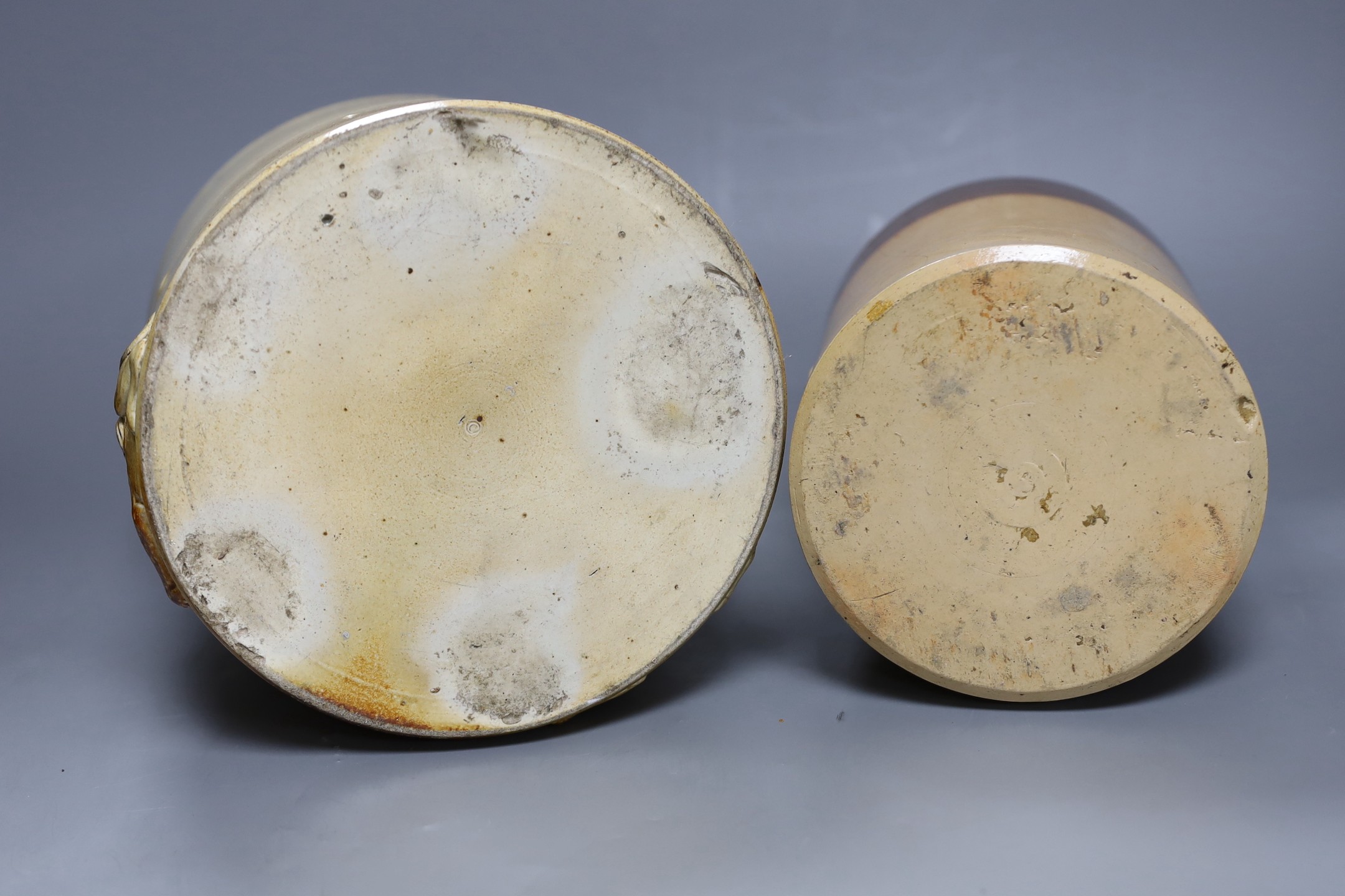 Two 19th century salt glazed stoneware cylindrical storage jars, both with Royal Coat of Arms sprigging, Tallest 20.5cm